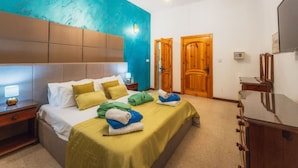 A hotel room with a bed, bedside tables, a wardrobe, and a door. - Tal Jordan Complex - Bungalow 3 Frog (Gharb)