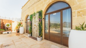 A stone building with arched windows and a tiled patio. - Tal Jordan Complex - Bungalow 3 Frog (Gharb)