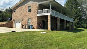 A two-story brick building with a covered porch and a garage.