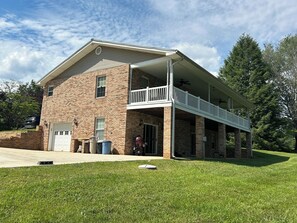 A two-story brick building with a covered porch and a garage.