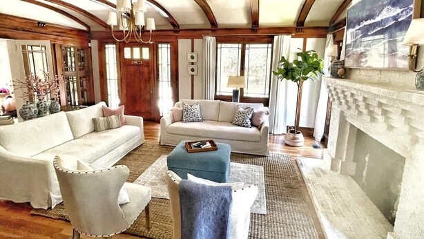 A spacious living room with a fireplace, two sofas, a coffee table, and a chandelier. - Pristine Craftsman 1900s Bungalow w Pool & Hot Tub (Savannah)