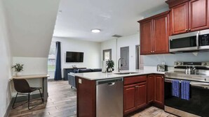 Una cocina moderna con armarios de madera, electrodomésticos de acero inoxidable y lavavajillas integrado.