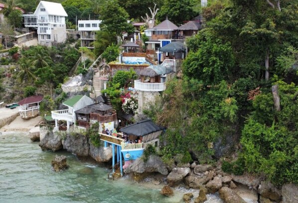 Propiedad costera con varias edificaciones, un muelle y un litoral rocoso.