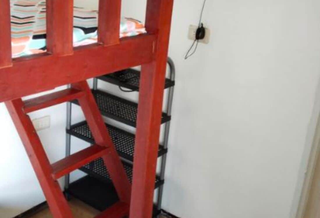 A red metal shelf unit with multiple tiers, likely used for storage or display.