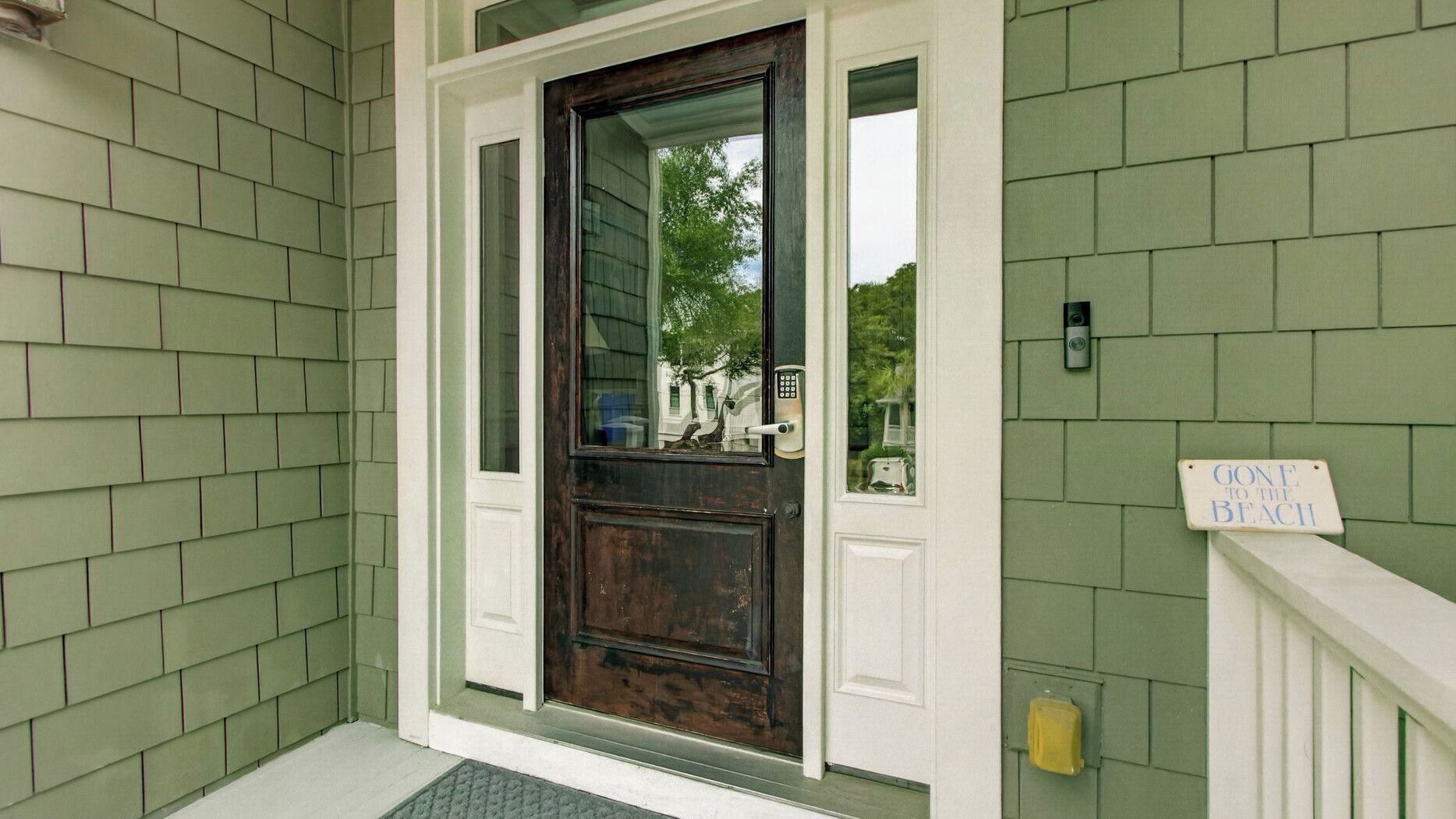 A front door with a dark wooden panel, a glass panel above it, and a small sign on the right.