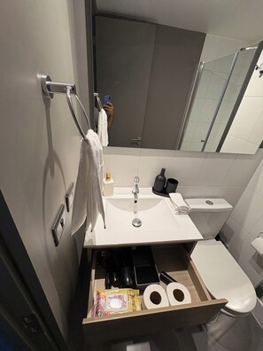 Een moderne badkamer met een wastafel, toilet en spiegel.