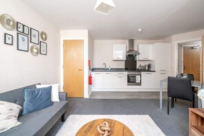 Ein modernes Apartment mit Wohnzimmer, Küche und Essbereich.