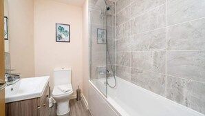 Un bagno con il water, lavandino e cabina doccia in vetro.