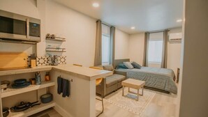 A compact room with a kitchenette, a bed, a sofa, and a small table. - ABQ Stunner Studio! Cute kitchen! Private parking! (Albuquerque)