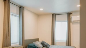 A compact bedroom with a bed, a small table, a sofa, and a desk. - ABQ Stunner Studio! Cute kitchen! Private parking! (Albuquerque)