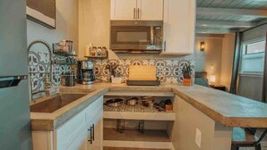 A compact kitchen with white cabinets, a microwave, and a coffee maker. - ABQ Hub Studio - Old Town Gem! (Albuquerque)