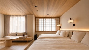 A hotel room with a wooden ceiling, a sofa, a bed, and a window with a view. - KIORI Collection Gokomachi (Kyoto)