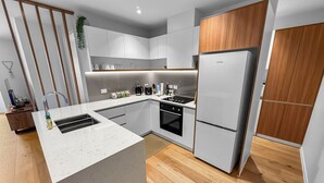 Una cucina moderna con isola centrale, forno integrato ed elettrodomestici in acciaio inossidabile.