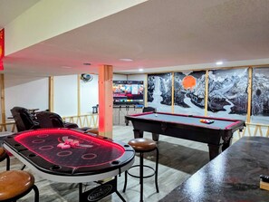 Ein Billardtisch, ein Pooltisch und eine Wand mit Wandgemälde.