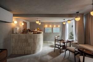 Una cocina moderna con una isla curva, sillas de madera e iluminación colgante.