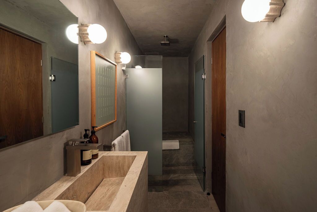 A modern bathroom with a large mirror, a bathtub, and a shower.