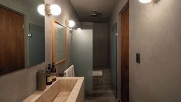 A modern bathroom with a large mirror, a bathtub, and a shower.
