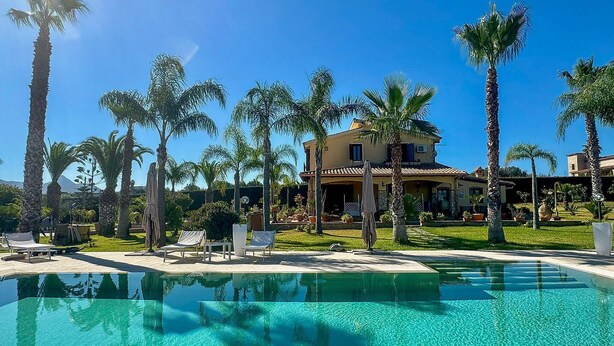A pool with clear water, surrounded by palm trees and lounge chairs. - Luxurious home in Partinico (Partinico)