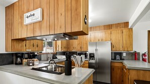 Una cucina moderna con mobili in legno, elettrodomestici in acciaio inossidabile e un angolo caffè.