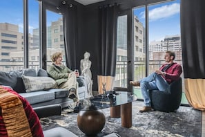 Ein modernes Interieur mit einer Couch, einem Glastisch und einer Statue.