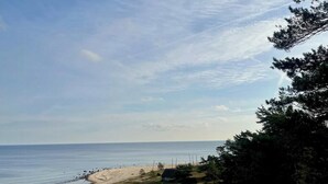 A coastal landscape with a sandy beach, grassy areas, and trees. - Charming cottage in scenic Brösarp Österlen (Kivik)