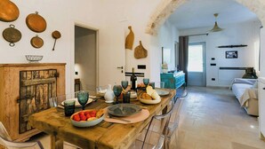 Un'area pranzo rustica con un tavolo di legno, diversi piatti e un arco in pietra.