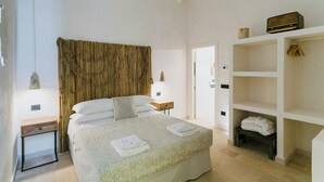 Una camera da letto con un letto, comodini, un armadio e una lampada a sospensione.