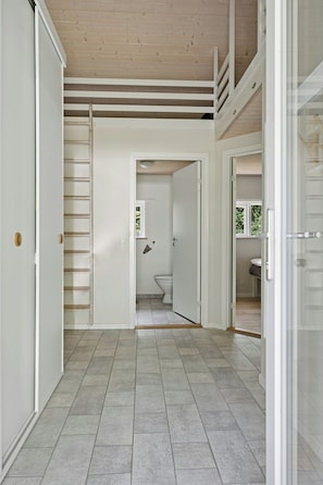 A hallway with a wooden ceiling, a staircase, and a bathroom visible through an open door. - Forest house with stream by Hjarbæk Fjord (Højslev)