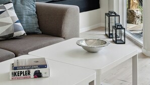 Une pièce moderne avec un canapé, une table, une fenêtre et une lampe.
