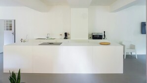 A modern kitchen with a white countertop, a coffee machine, and a microwave. - Design apartment in the historic Mittermurnthal (Neunburg vorm Wald)