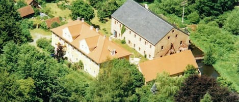 Ett flygbildsbild av ett stort gods med flera byggnader, en flod och tät vegetation.