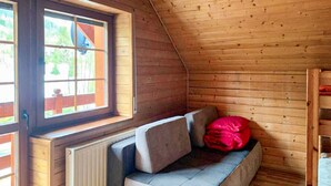 Um quarto de sótão acolhedor com um banco embutido, uma janela e um radiador.