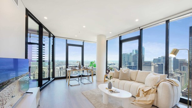 Un salon moderne avec un canapé, une table basse et une vue sur la ville.
