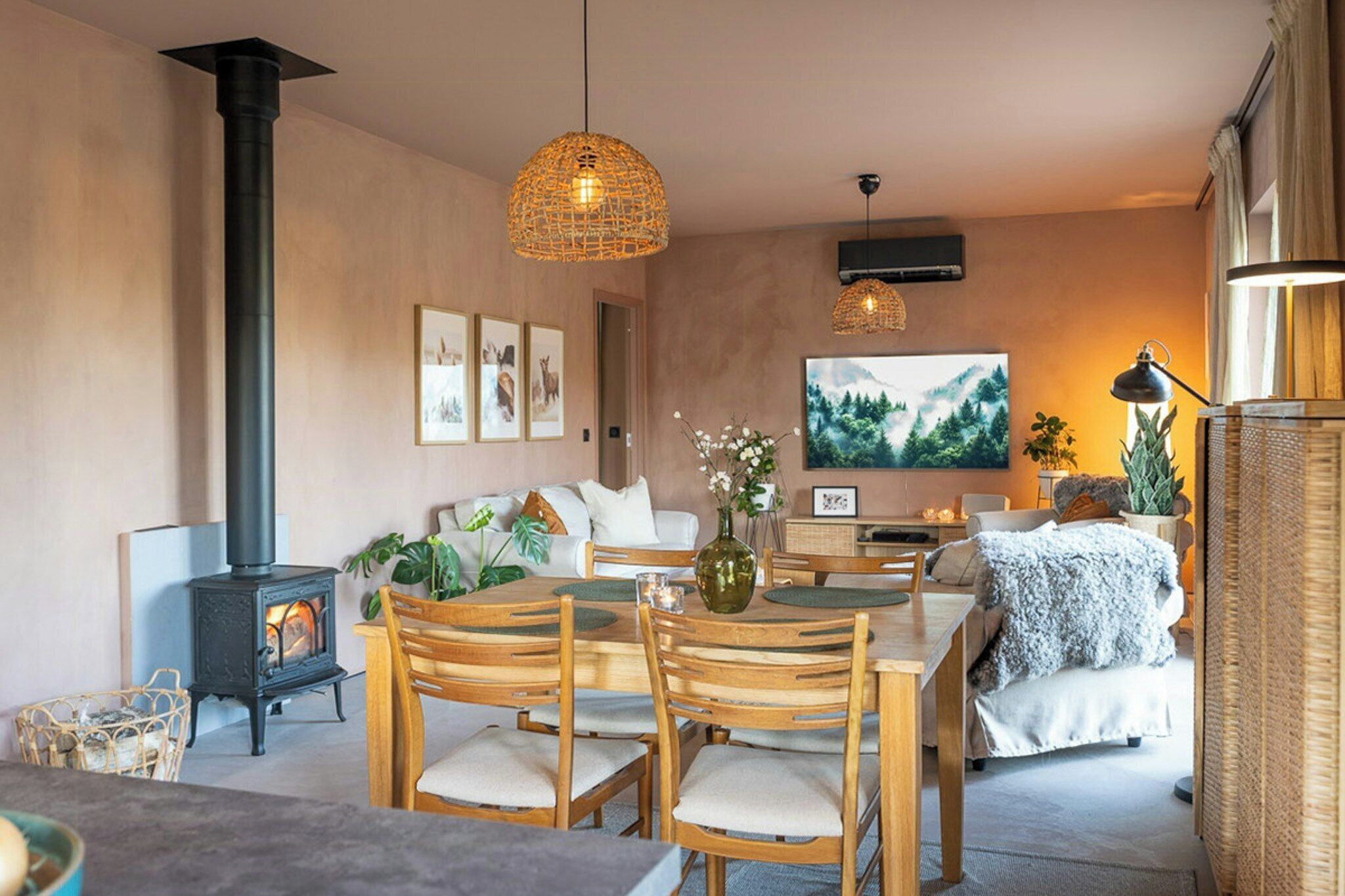 A cozy living room with a fireplace, wooden furniture, and a large TV.