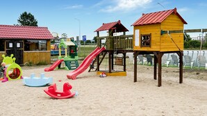 A playground with slides, climbing structures, and a wooden playhouse. - Amazing home in Jaroslawiec with sauna (Jaroslawiec)