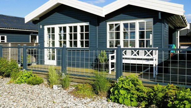 Un bâtiment à deux étages, à la façade bleu foncé, aux ornements blancs et doté de nombreuses fenêtres.