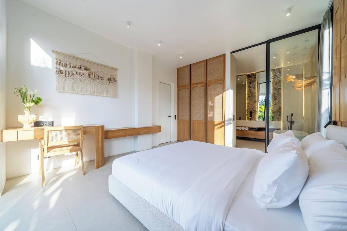 Un dormitorio moderno con una cama grande, un escritorio y un armario.