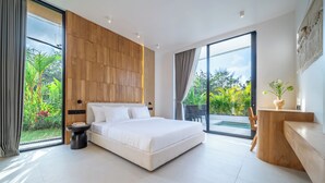 Ein modernes Schlafzimmer mit einem großen Bett, einer Wand in Holzoptik, einem kleinen Nachttisch und Blick ins Grüne.