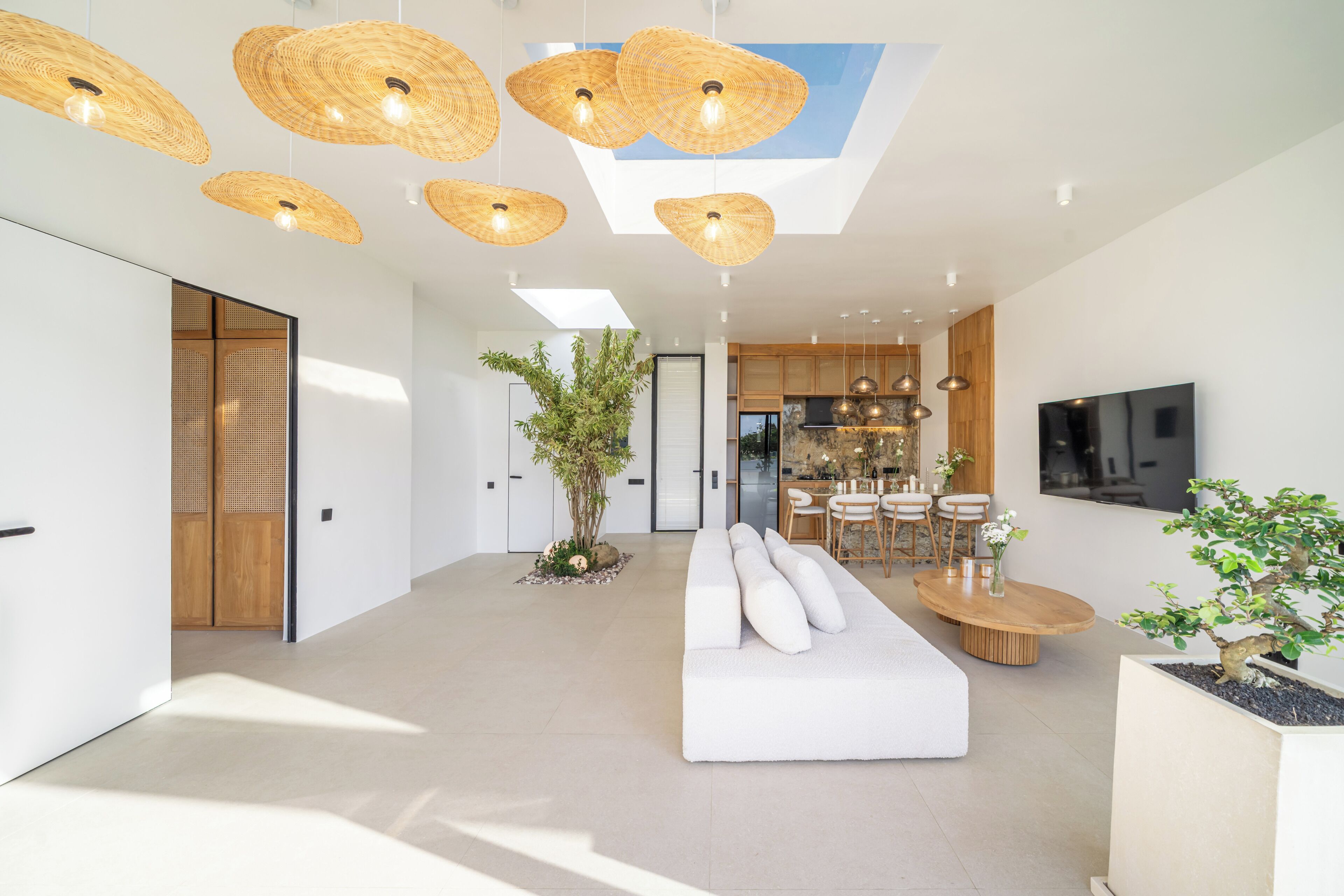 A modern living room with a sofa, dining area, and kitchen.