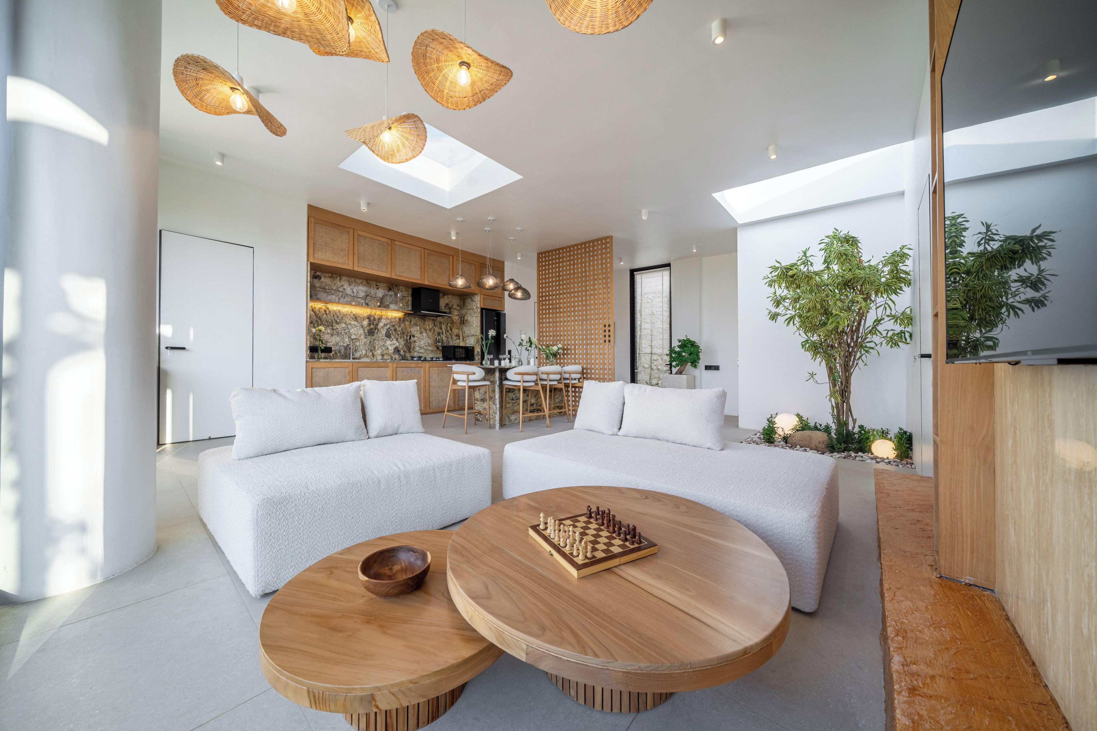 A modern living room with a sofa set, a coffee table with a chessboard, and a dining area with a wooden table and chairs.
