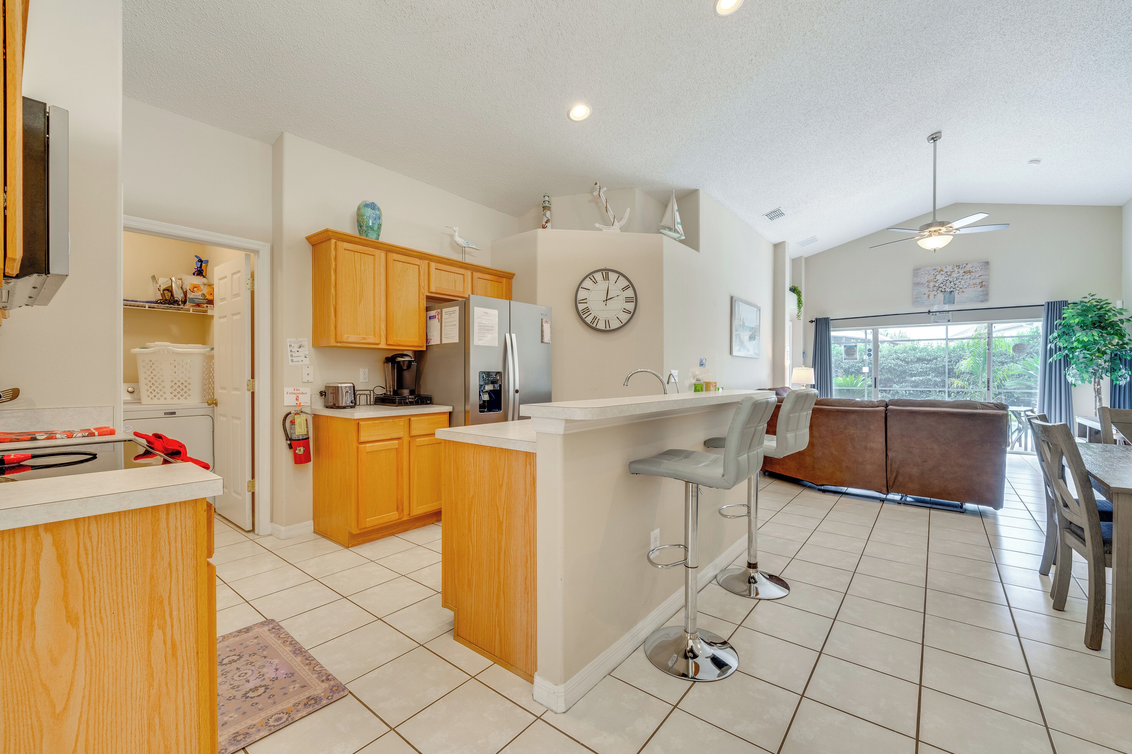 A modern kitchen with wooden cabinets, a central island, and a bar area.