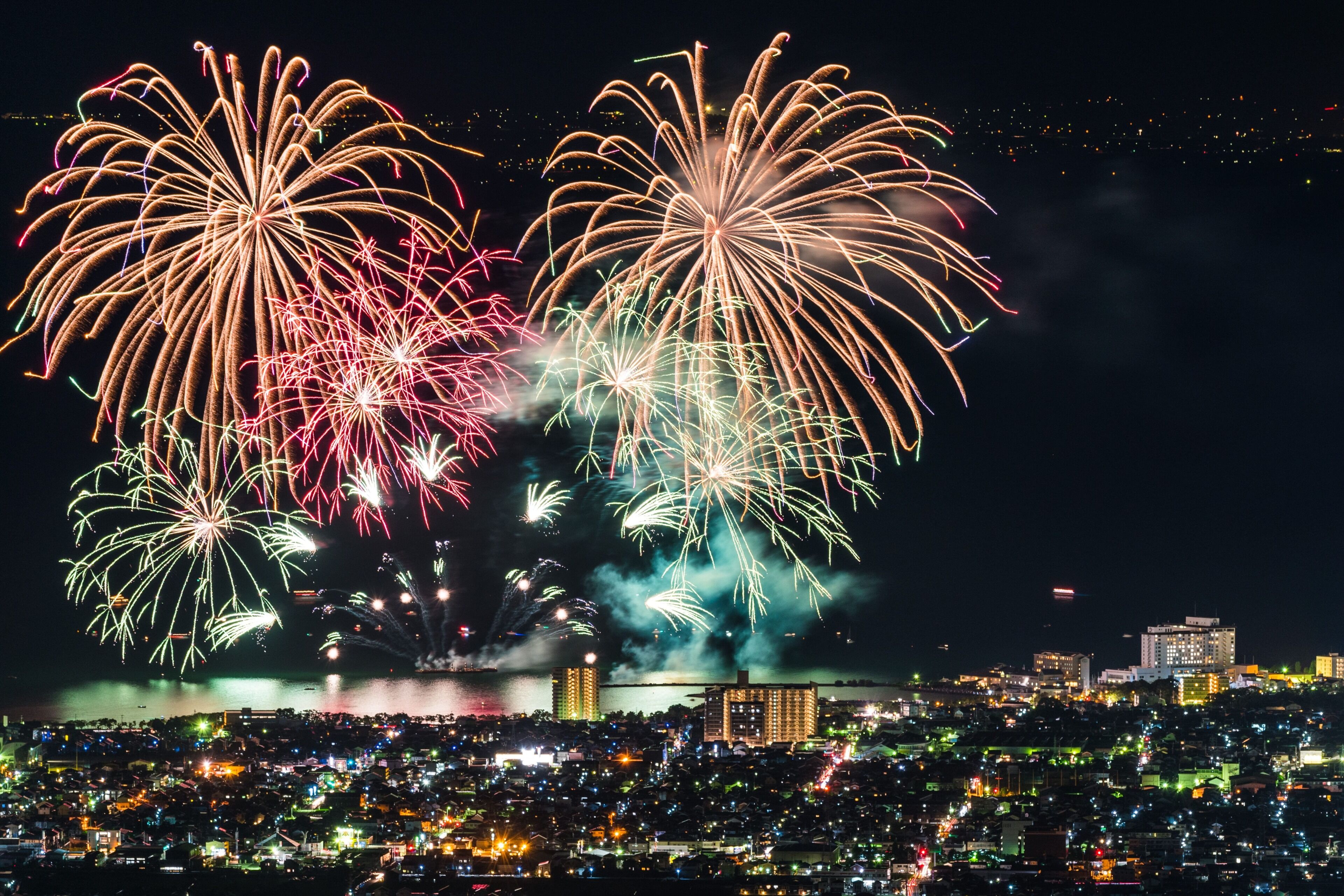 Panoramica notturna della città con fuochi d'artificio.