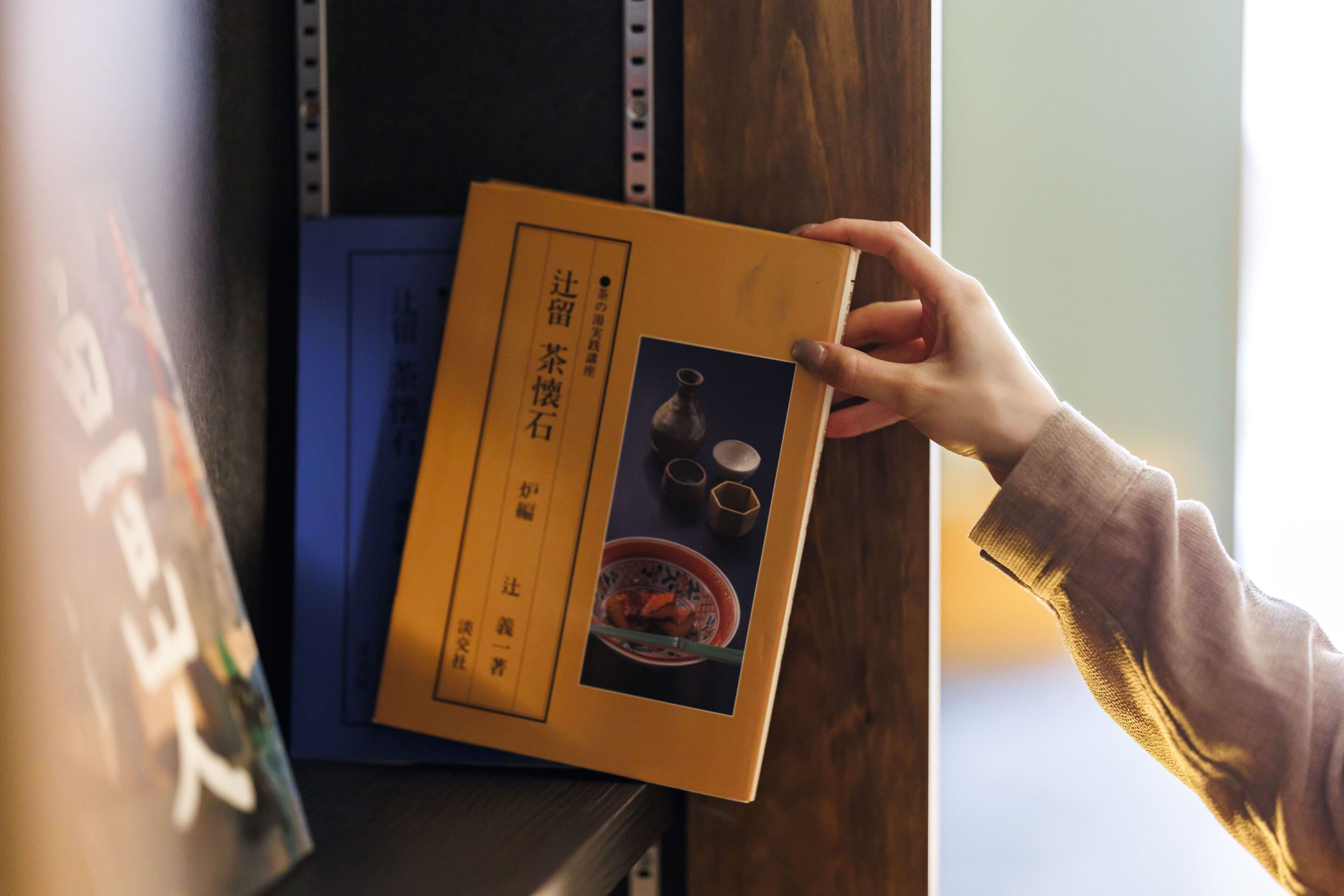 Une personne tenant un livre contenant du texte en chinois et une image d’un bol de nourriture.