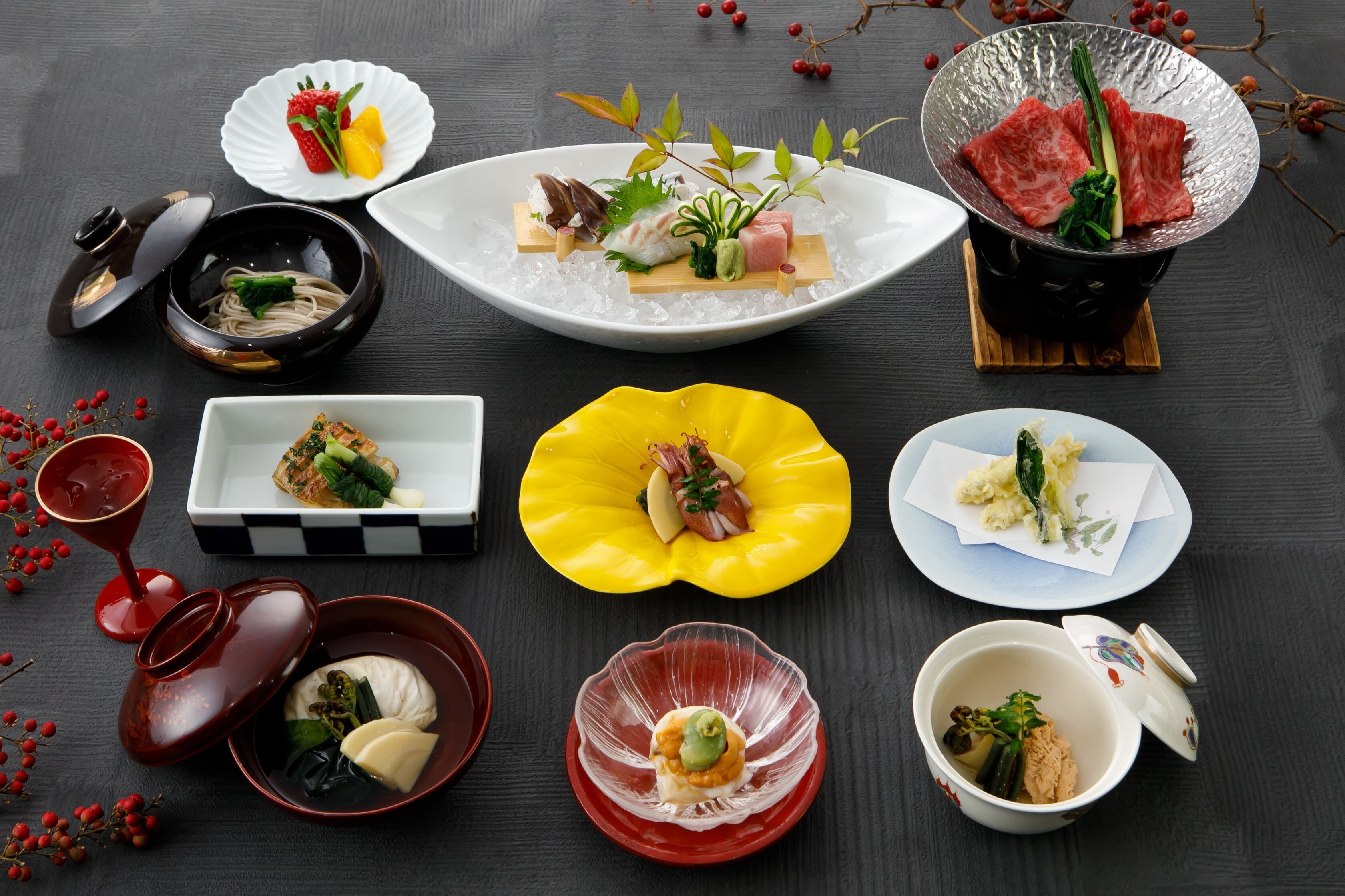 Diverses platillos disposats sobre una taula, incloent sushi, sashimi i altres plats de cuina asiàtica.