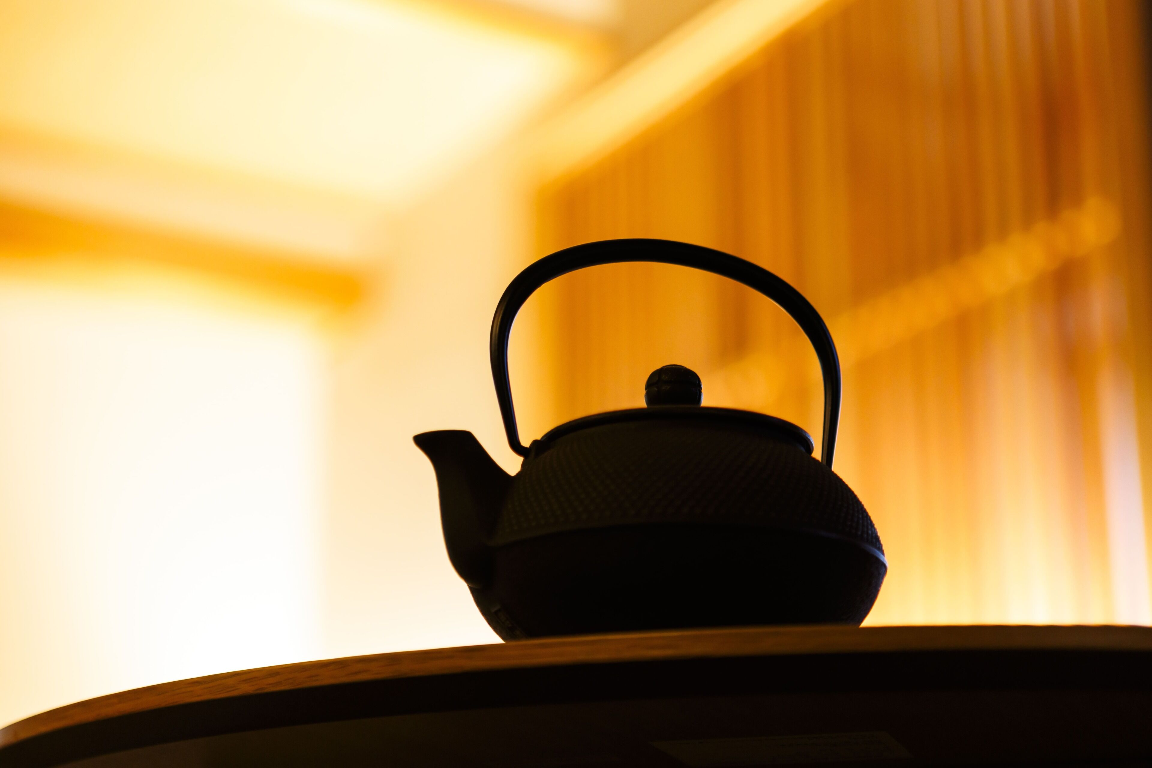 A teapot on a table with a blurred background.