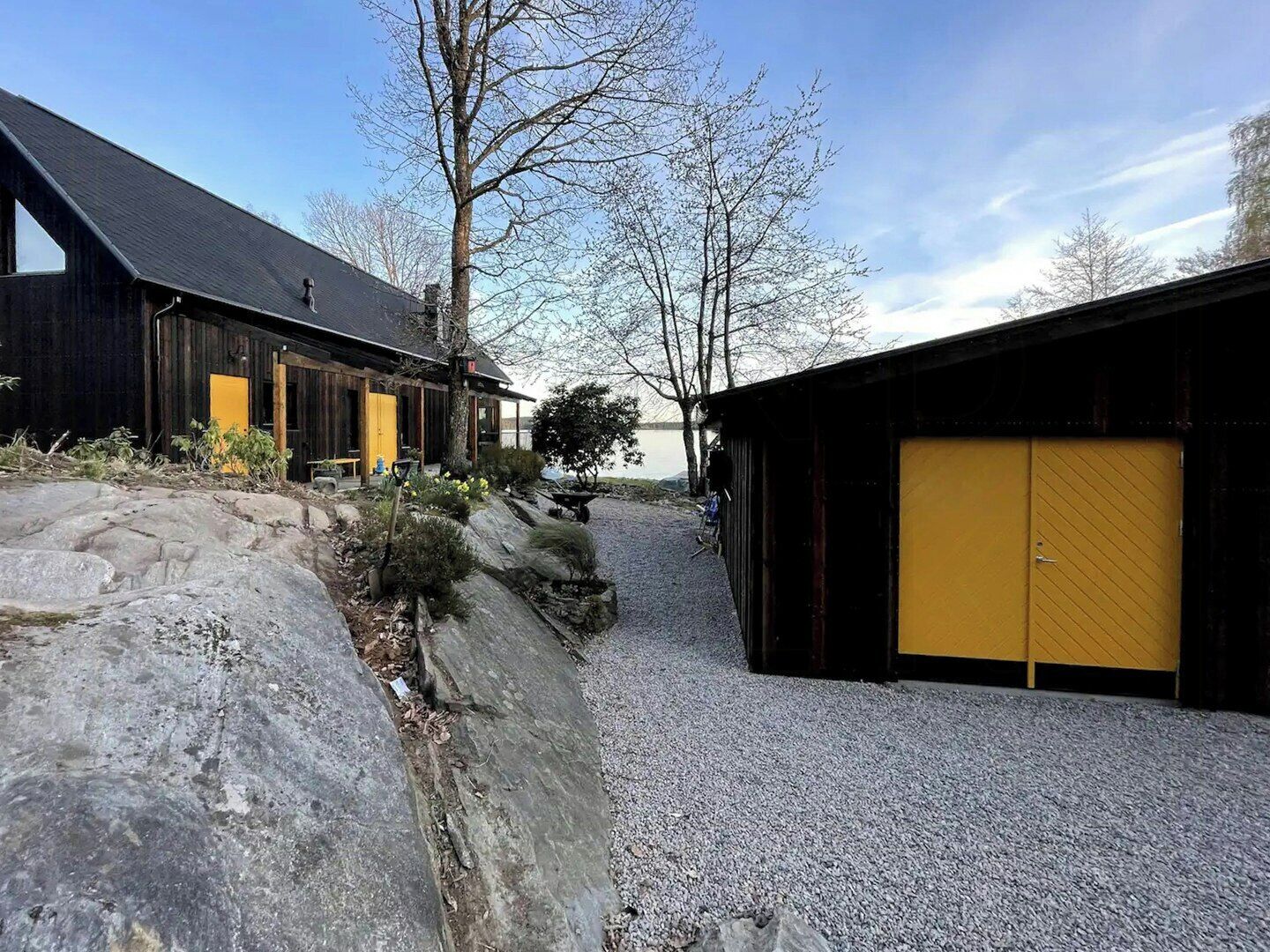 A building with a gravel path, wooden structures, and a yellow door.