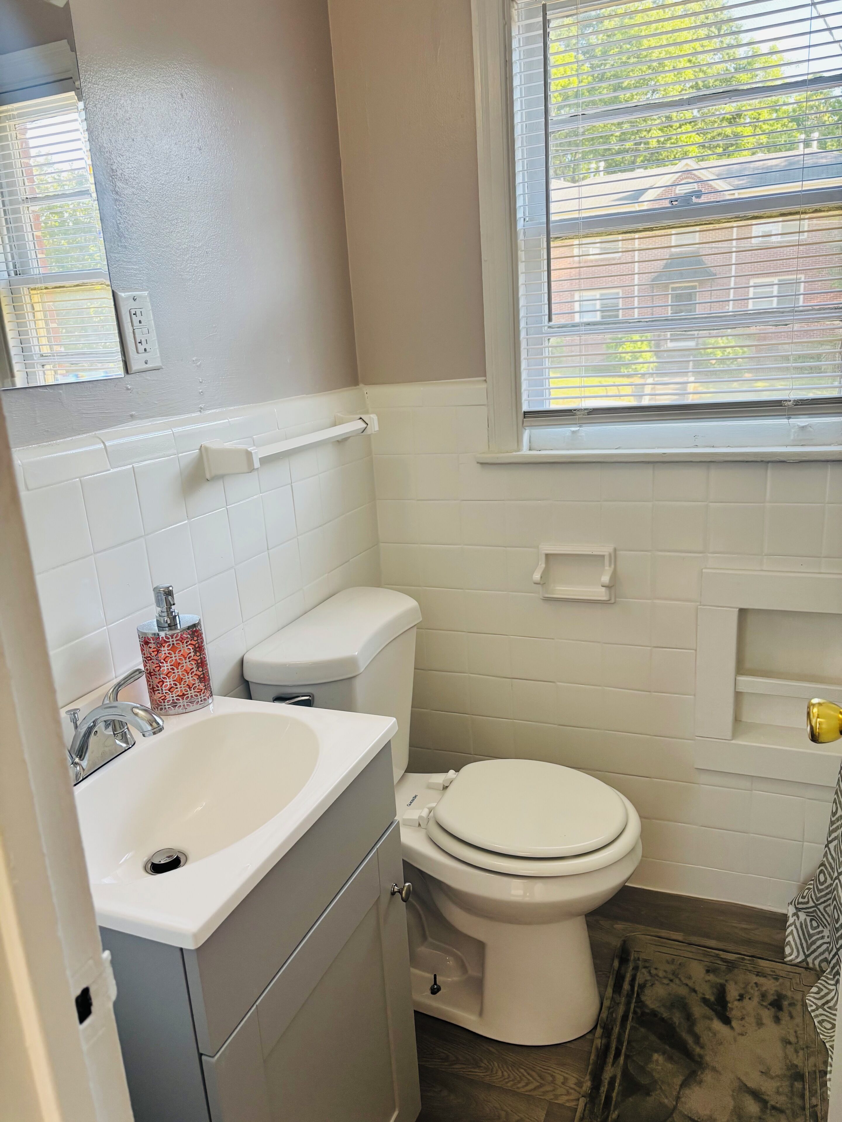 Un baño con inodoro, lavamanos y ventana.