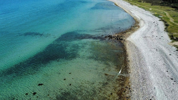 Ett kustlandskap med en vacker strand och hav.