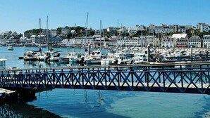 A marina with boats docked, a pier, and buildings in the background. - Contemporary haven on the Breton coast (Plouhinec)