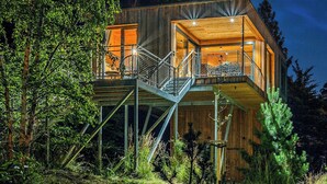 A modern wooden cabin with a glass balcony, surrounded by trees. - Treetop house near Mount Brocken (Ilsenburg)